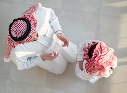 Arab father and son talking, directly above view