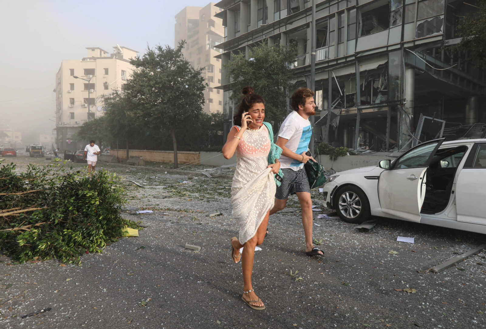 People run for cover following an explosion in Beirut's port area