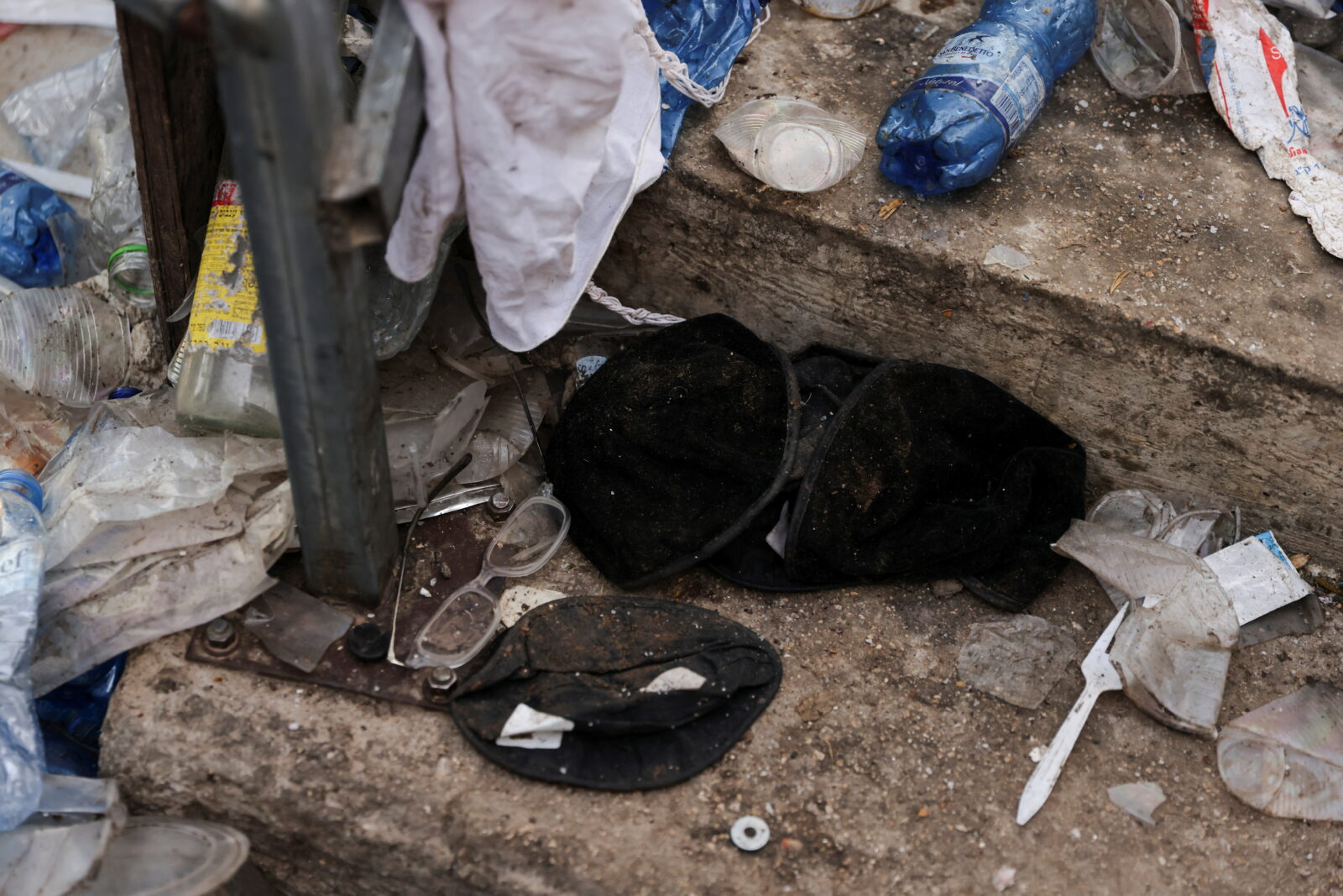 Black yarmulkas seen on stairs with other waste on it as well in Mount Meron