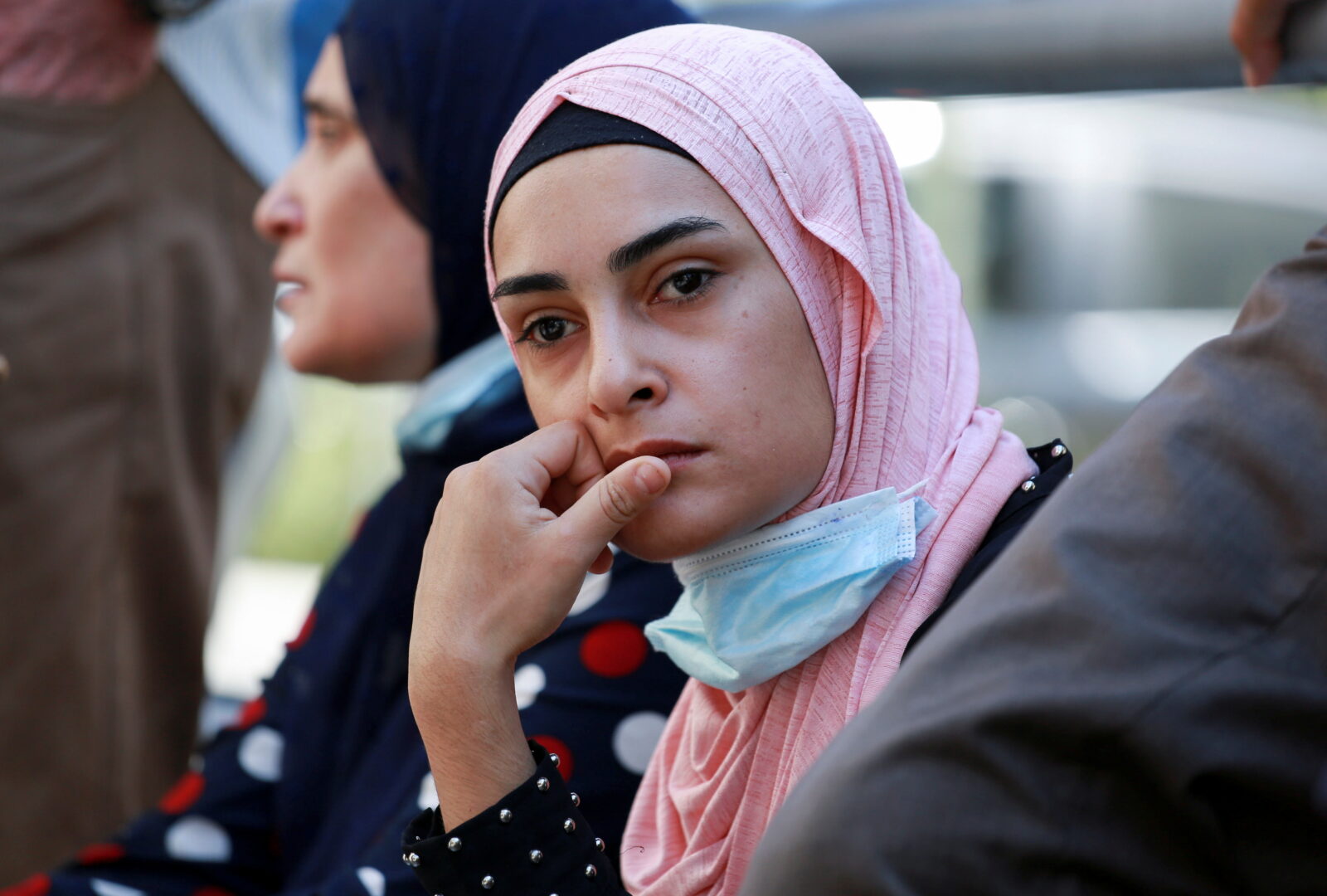 Women wait outside a hospital in Beirut