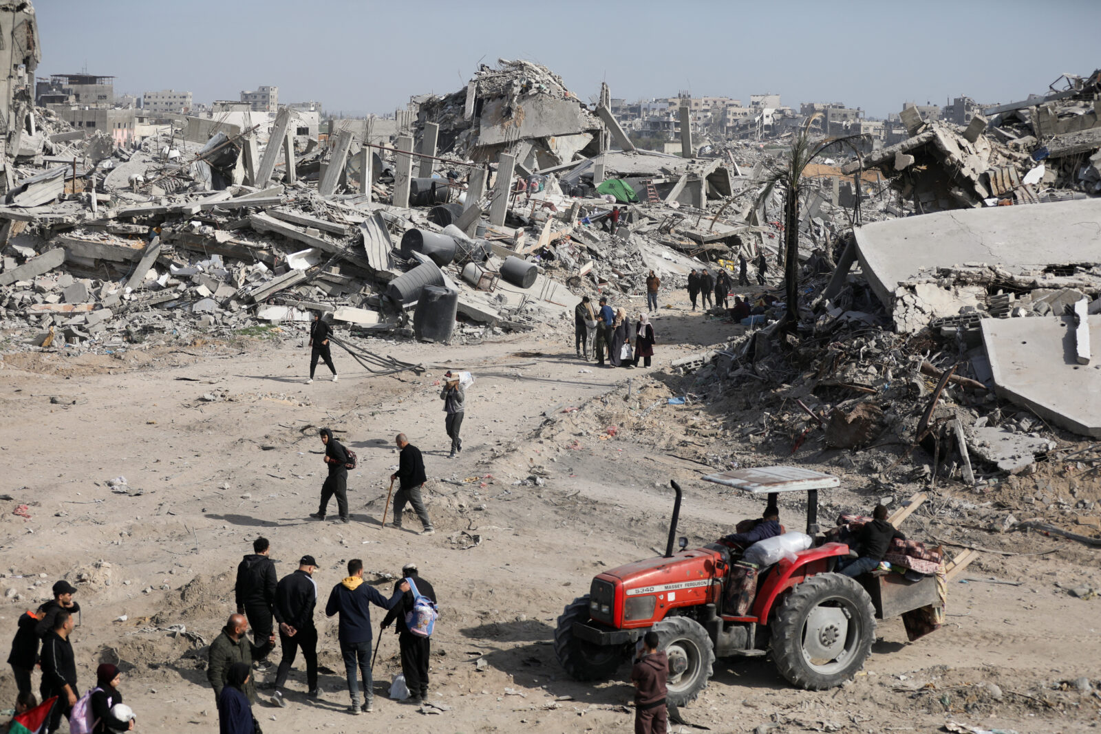 Displaced Palestinians walk past the rubble as they attempt to return to their homes, in the northern Gaza Strip