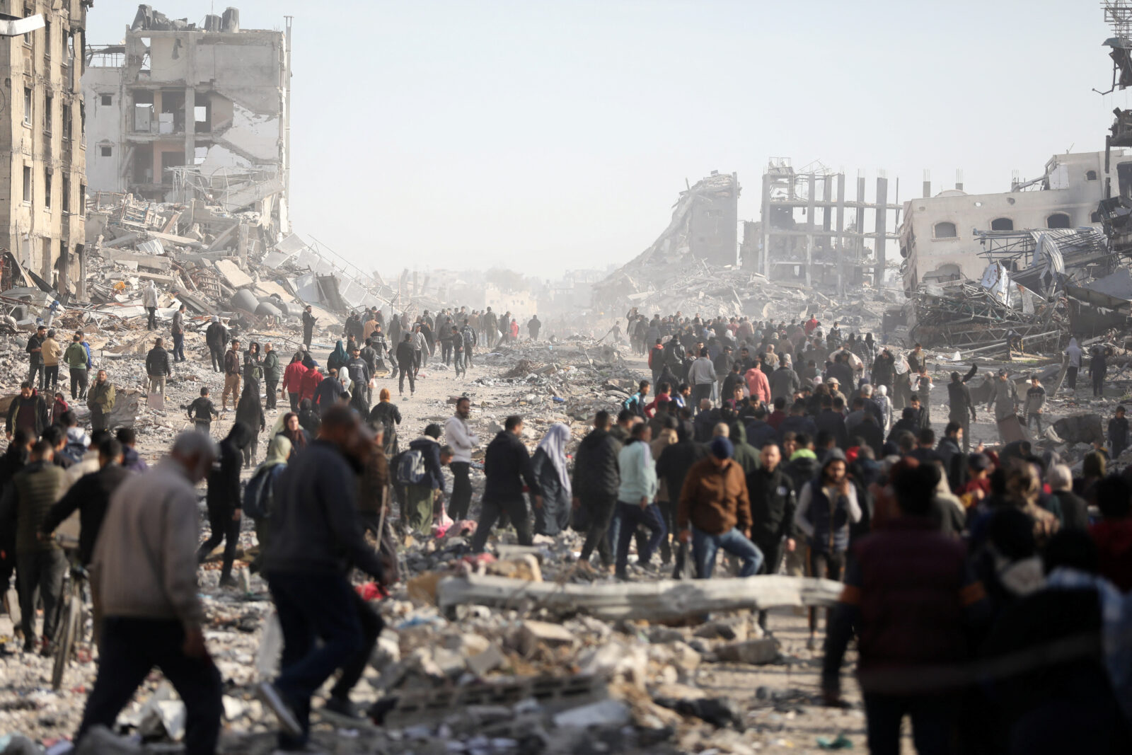 Displaced Palestinians walk past the rubble as they attempt to return to their homes, in the northern Gaza Strip