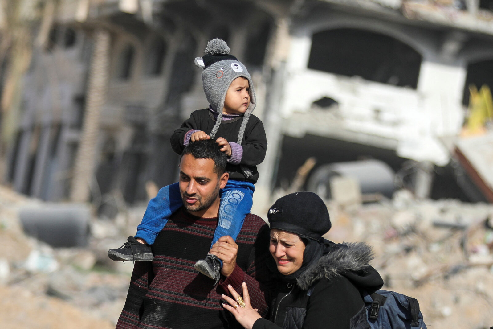 Displaced Palestinians walk past the rubble as they attempt to return to their homes, in the northern Gaza Strip