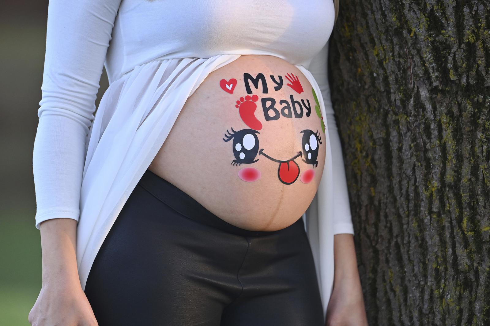 Pregnant woman shows her baby belly.