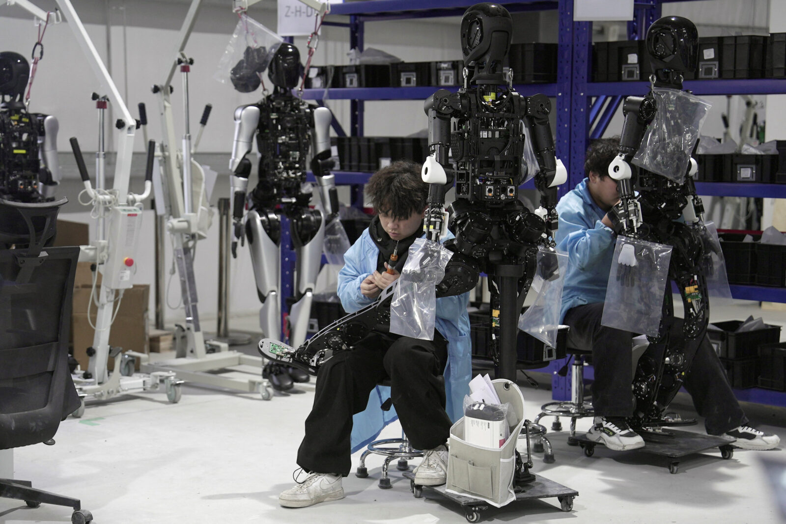 Engineers work on humanoid robots at an Agibot factory in Shanghai