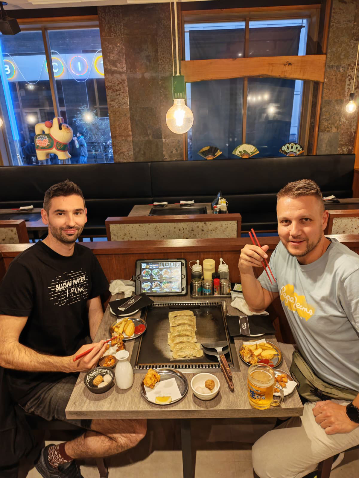 Budućnost-restorana-Josip-i-Dražen-koriste-tablet-za-naručivanje-večere,-dok-iščekuju-prve-komade-mesa-na-vrelom-ugrađenom-roštilju/Privatni album
